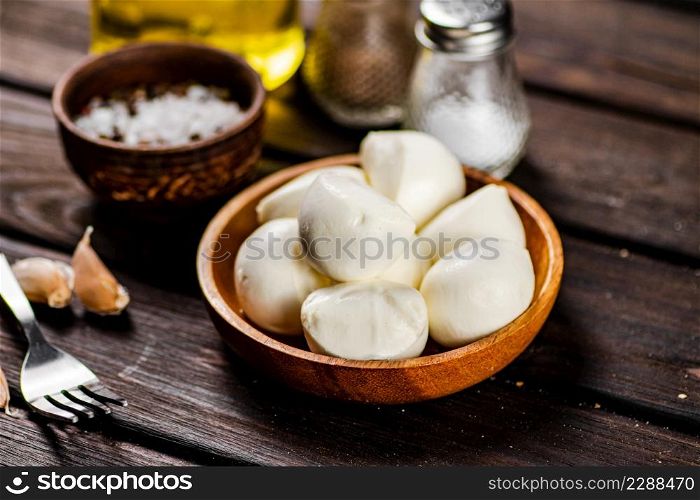 Mozzarella cheese with garlic. On a wooden background. High quality photo. Mozzarella cheese with garlic. On a wooden background.