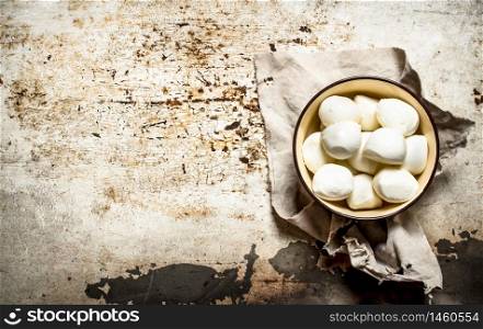 Mozzarella in bowl on old fabric. On rustic background .. Mozzarella in bowl on old fabric.
