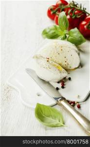 mozzarella, organic cherry tomatoes and fresh basil on a rustic wooden background