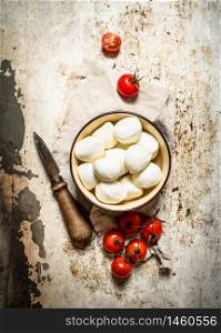 Mozzarella with fresh tomatoes . On rustic background .. Mozzarella with tomatoes .