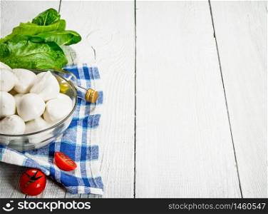 Mozzarella with tomatoes and herbs .On a white wooden background. Mozzarella with tomatoes and herbs .