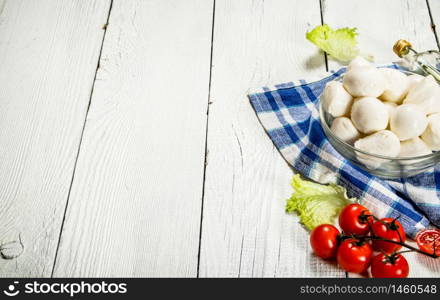 Mozzarella with tomatoes and herbs .On a white wooden background. Mozzarella with tomatoes and herbs .