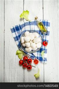 Mozzarella with tomatoes and herbs .On a white wooden background. Mozzarella with tomatoes and herbs .