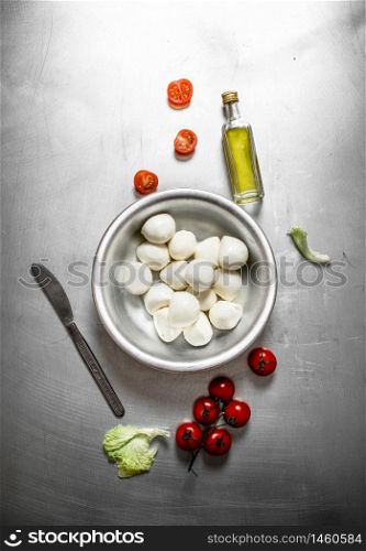Mozzarella with tomatoes and olive oil. On the metal table.. Mozzarella with tomatoes and olive oil.