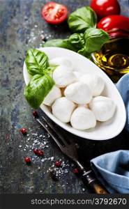 Mozzarella with tomatos and basil leaves on Wooden background