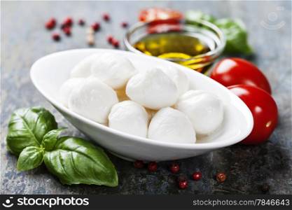 Mozzarella with tomatos and basil leaves on Wooden background