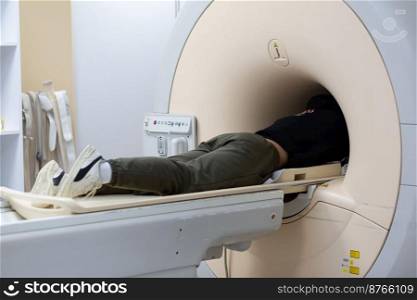 MRI  magnetic resonance imaging  scanner in a hospital, with patient being scanned and diagnosed. Modern medical equipment, medicine and health care concept. SELECT VE FOCUS