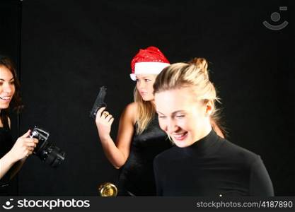 Mrs. Santa posing with hand gun on dark background