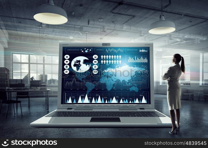 Much work to be done. Young businesswoman in modern interior and big laptop with graphs and diagrams