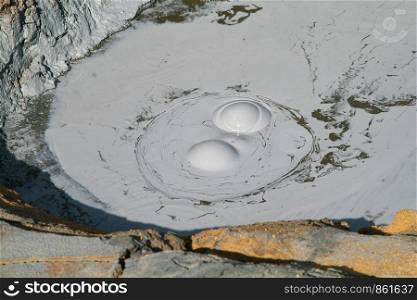 Mud hole bubbles boiling hot and makes gray bubbles