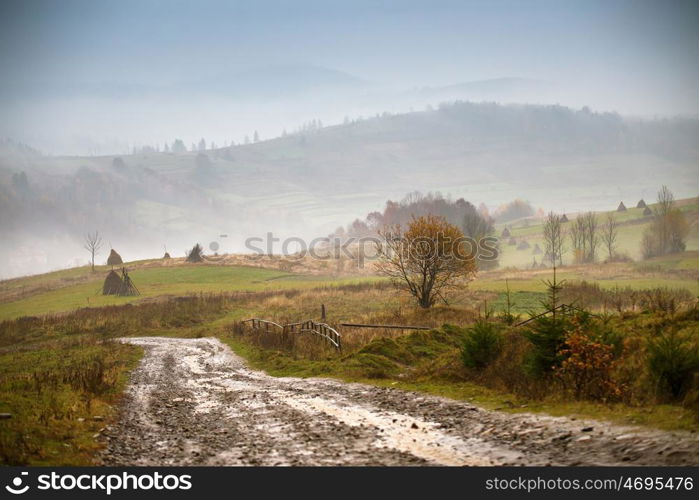 Muddy ground and country road after rain in Carpathian mountains. Extreme path rural dirt road in the hills. Bad weather