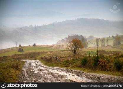 Muddy ground and country road after rain in Carpathian mountains. Extreme path rural dirt road in the hills. Bad weather