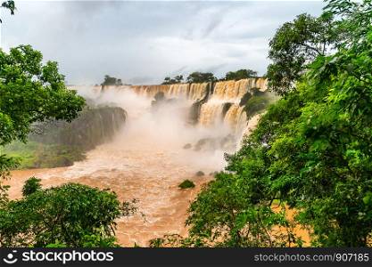 Muddy Iguazu falls at the border of Argentina and Brazil in rainy season.