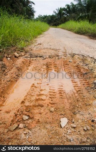 muddy road with pothole, bad condition.