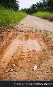 muddy road with pothole, bad condition.