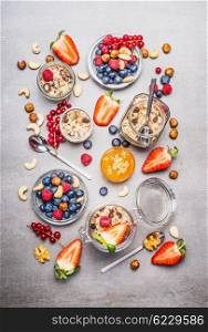 Muesli or granola in jars, fresh berries, seeds and nuts , top view. Healthy breakfast flat lay