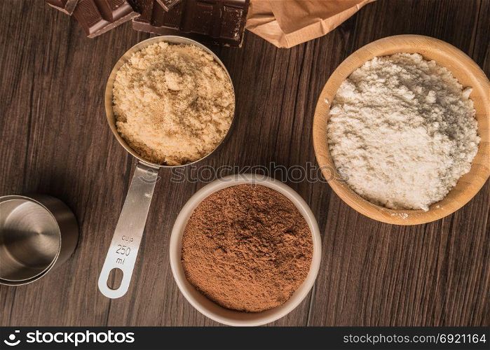Muffins baking ingredients on wooden table.