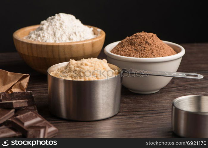 Muffins baking ingredients on wooden table.