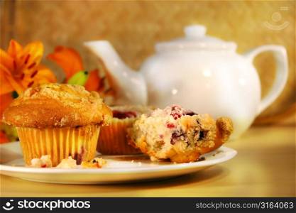 Muffins on a plate and a pot of tea