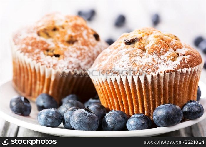 muffins with fresh blueberries on wooden table