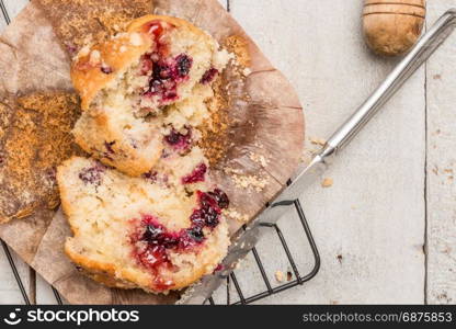 Muffins with red fruits jam fill on wooden counter top.