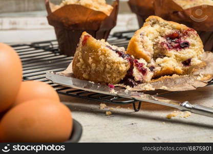 Muffins with red fruits jam fill on wooden counter top.