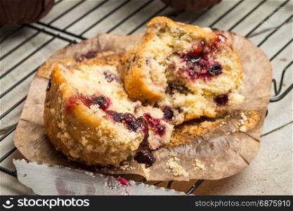 Muffins with red fruits jam fill on wooden counter top.