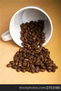 Mug and grains of coffee on a table