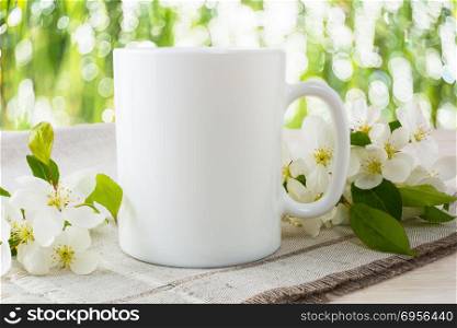 Mug mockup with apple blossom. Mug mockup with apple blossom. Mug mockup. Coffee cup template. Coffee mug template. Mug template. Mug design template. Mug design. Mug printing design. White mug mockup. Cup mockup. Blank mug.