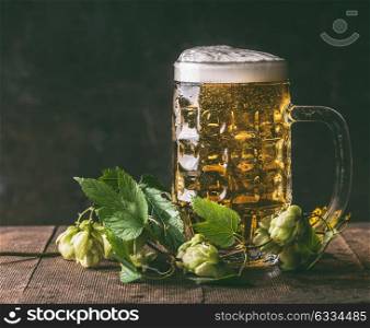 Mug of beer hops on dark rustic background,front view, copy space. German style