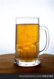 Mug of beer on wooden background. Glass with beer on a wooden table