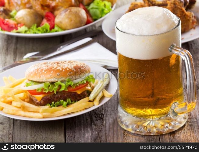 mug of beer with hamburger and fries