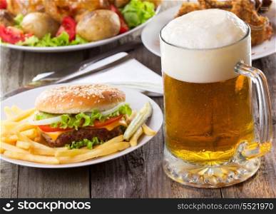 mug of beer with hamburger and fries