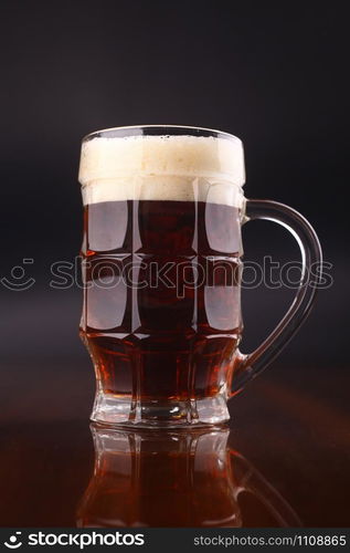 Mug of dark beer over a dark background