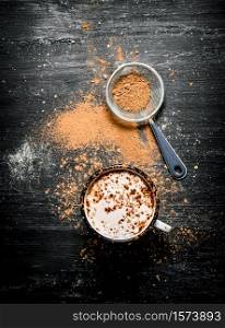 Mug of hot chocolate with crushed cocoa. On black rustic background.. Mug of hot chocolate with crushed cocoa.