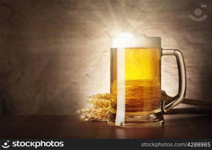Mug of lager beer with a solar flare on burlap background