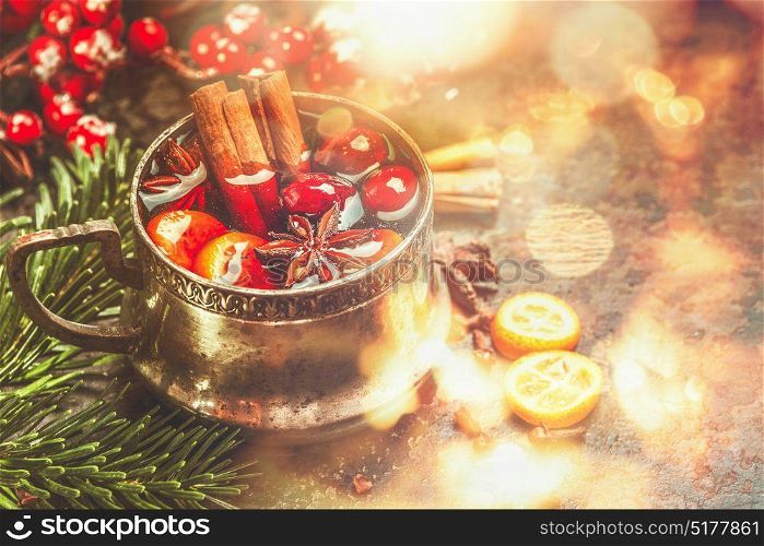 Mug of mulled wine with spices at festive Christmas background with bokeh lighting
