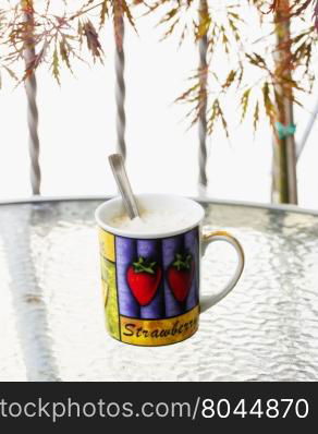 Mug outdoor over a table, vertical image