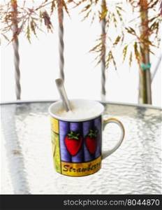 Mug outdoor over a table, vertical image