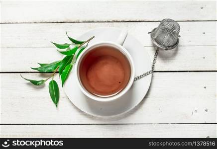 Mug with black tea. On a white wooden table.. Mug with black tea.