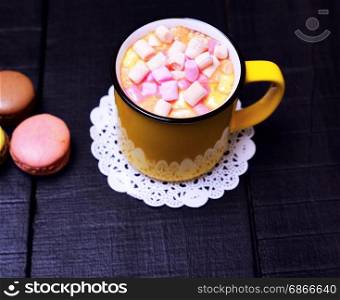 mug with cocoa and pieces of colorful marshmallow, top view
