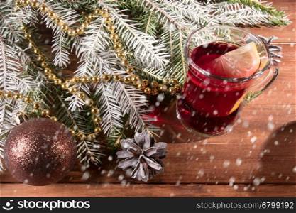 Mug with mulled wine, fir branches on wooden background. Vintage style