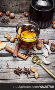 Mulled wine and spices. glass of mulled wine with almonds,cinnamon and anise on background of carafe of wine