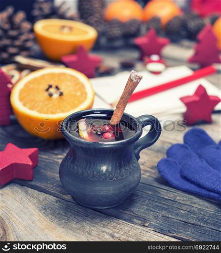 mulled wine in a brown ceramic cup on a gray wooden background