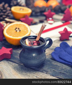 mulled wine in a brown ceramic cup on a gray wooden background