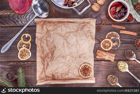 mulled wine in an iron casserole and an empty paper scroll for recording a drink recipe, top view