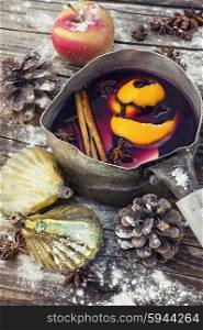 Mulled wine in the old pot. Brewed mulled wine with spices in a stylish pot and Christmas decorations