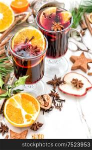 Mulled wine on white background. Hot winter cocktail with fruits and spices. Christmas table decoration
