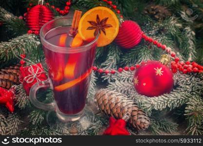 mulled wine with decorated christmas tree in snow close up, retro toned