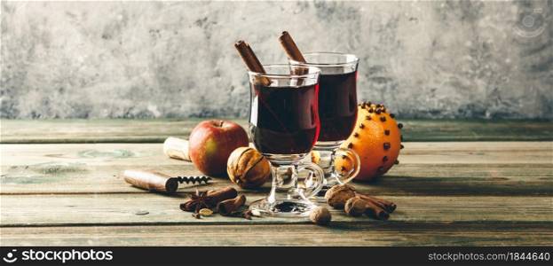 Mulled wine with spices and orange slices on wooden table. Mulled wine with spices and orange slices on wooden table, banner